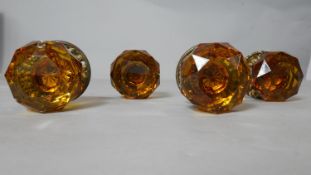 A pair of Victorian amber faceted glass gilded door knobs with repousse work plates.