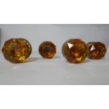 A pair of Victorian amber faceted glass gilded door knobs with repousse work plates.
