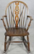 A vintage Windsor wheel back rocking chair with elm seat. H.90cm