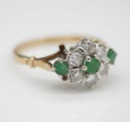 A vintage diamond, emerald and 9 carat gold floral cluster ring. Set with three round mixed cut