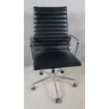 An Eames inspired desk chair in ribbed black leather upoholstery on chrome frame and base. H.110 W.