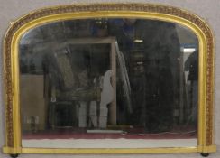 A Victorian gilt overmantel mirror with arched plate and gesso floral decoration on porcelain bun