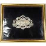 A framed and glazed silver Venetian Milagro mask made from pierced white metal with scrolling and