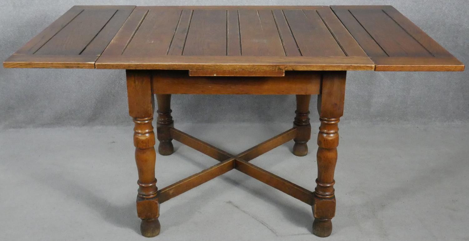 A mid century oak draw leaf table on turned stretchered supports. H.75 W.92 D.92cm - Image 2 of 4