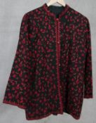 A black woolen crewel work jacket, embroidered with flowers and leaves, with toggle fastenings. L.