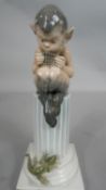 A Royal Copenhagen porcelain figure of a faun playing pan pipes seated on column with a lizard on