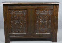 A mid century oak antique style coffer with carved panels on block feet. H.56 W.76 D.30cm