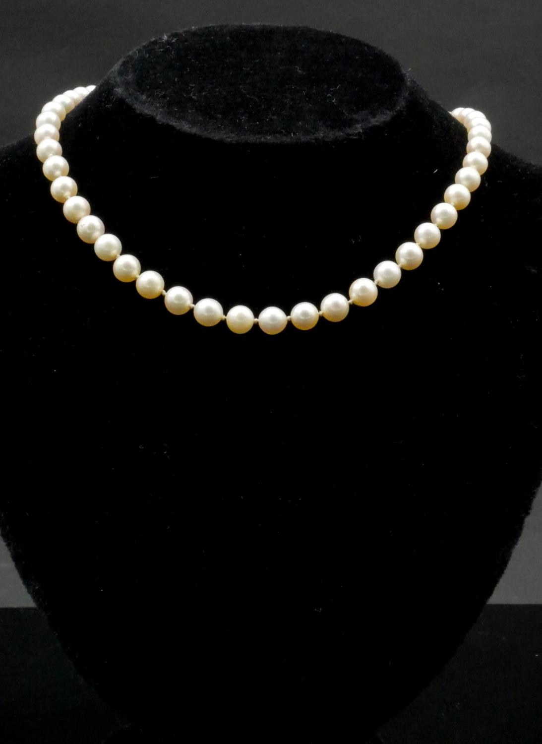 A 14 carat white gold knotted cultured pearl necklace. The necklace has forty nine round pearls with