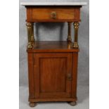 A late 19th century French Empire style fruitwood bedside cabinet with marble top and frieze
