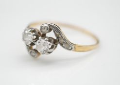 An Edwardian old mine diamond and yellow metal cross over ring. Set with two cushion shape old