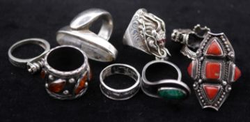 A collection of eight gemset and silver rings. Including a amber and silver ring, a silver puzzle