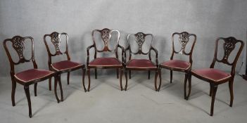 A set of six late 19th century mahogany salon dining chairs with carved and pierced splats raised on