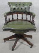 A vintage captain's desk chair in deep buttoned and studded leather upholstery with tilt and