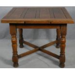 A mid century oak draw leaf table on turned stretchered supports. H.75 W.92 D.92cm