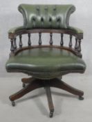 A vintage captain's desk chair in deep buttoned and studded leather upholstery with tilt and