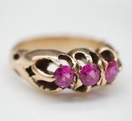 A 14 carat yellow gold and ruby three stone gypsy ring. Set with three round old cut rubies with a