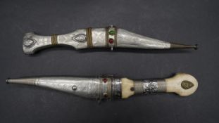 Two Bedouin Shibriya daggers, one with a repousse and engraved metal handle and sheath the other