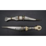 Two Bedouin Shibriya daggers, one with a repousse and engraved metal handle and sheath the other