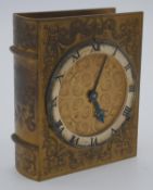 A mid 20th century gilded metal book clock made by Angelus, the front of the book engraved with