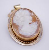 A 1970's 9 carat yellow gold and shell cameo pendant/brooch. A carved shell cameo depicting a side