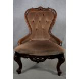 A Victorian style carved mahogany nursing chair in buttoned upholstery. H.89 W.55 D.45