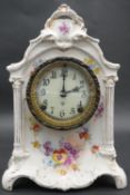 An Ansonia porcelain mantel clock with enamel dial and black Roman numerals, decorated with floral