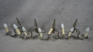 A set of four metal twin sconce wall candelabras with scrolling foliate arms. H.31 W.29