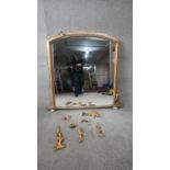 A Victorian overmantel mirror in arched gilt frame and original plate resting on porcelain bun feet.