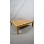 A contemporary light oak low table on square tapering supports. H.31 W.90 D.90