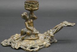 A C.1900 cast brass chamber stick of cast young faun holding a flower with basket at his feet, the