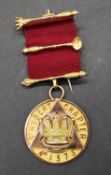 A 9 carat yellow gold St Cutbert Chapter Masonic medal with red silk ribbon. Inscribed 'E. Comp.