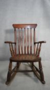 A 19th century stick back rocking Windsor armchair with elm seat. H.107 W.55 D.42