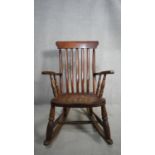 A 19th century stick back rocking Windsor armchair with elm seat. H.107 W.55 D.42