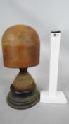 A 19th century carved wooden milliners hat stand with turned base and sitting on ebony plinth.