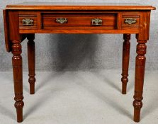 A late 19th century walnut single drop flap table fitted with three frieze drawers on turned