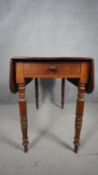 A 19th century mahogany drop flap Pembroke table fitted with frieze drawer on turned tapering