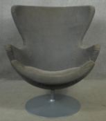 A swivel armchair in the style of an Arne Jacobsen egg chair on circular platform base. H.102cm