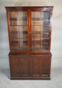 A mid century Georgian style mahogany library bookcase the upper glazed section above base fitted