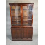 A mid century Georgian style mahogany library bookcase the upper glazed section above base fitted