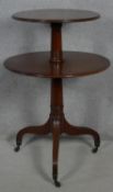 A late Georgian mahogany two tier dumb waiter on turned column and reeded tripod supports