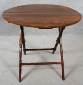 A 19th century walnut folding table on turned stretchered supports. H.65 D.76cm