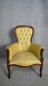 A Victorian style mahogany framed armchair in deep buttoned leather upholstery. H.104