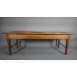 A 19th century pine refectory dining table with planked top on square tapering stretchered end