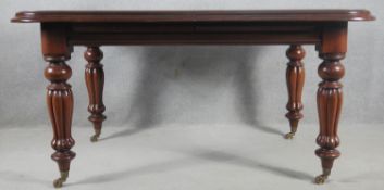 A William IV style mahogany extending dining table with extra leaf, winding mechanism and handle,
