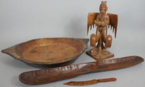 A collection of carved wooden items. Including an oriental carved statue of a deity, a two handled