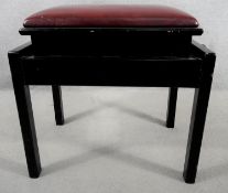 An adjustable black lacquered piano stool in leather upholstery stamped John Austin Furniture to the