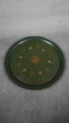 A very large round toleware dark green tray decorated with flowers and gilded scrolling details. H.
