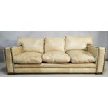 An Andrew Martin three seater sofa in studded leather upholstery resting on block supports. H.90 W.