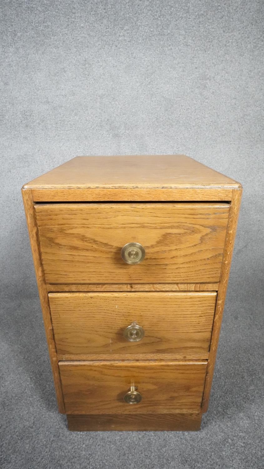 A mid century light oak three drawer pedestal chest on plinth base. H.63 W.35 D.46