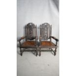 A pair of 19th century oak Carolean style throne armchairs with carved backs and leather